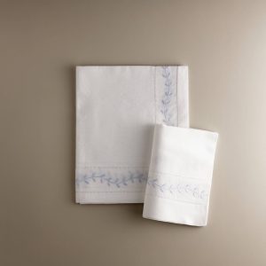 Sábana encimera de cuna con hojas bordadas en azul y funda de almohada